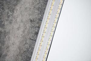 luz led de tira com perfil de alumínio no tecto falso, close-up. conceito de renovação em casa foto