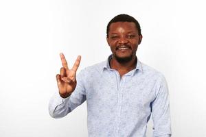 feliz homem negro afro-americano com gesto de sinal v em fundo branco de camisa brilhante casual foto