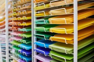 papéis de arte coloridos em exposição de prateleira em papelaria foto