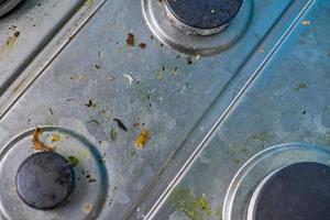 fogão sujo com respingos de óleo, manchas de gordura e restos de comida foto