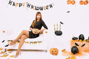jovem mulher com abóbora preta na decoração de halloween foto