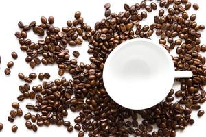 xícara de café branco e grãos de café.