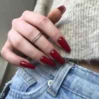 manicure feminino vermelho na moda elegante. mãos de uma mulher com manicure vermelho nas unhas foto