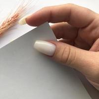 manicure feminina branca na moda elegante. mãos de uma mulher com manicure branca nas unhas foto