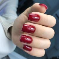 manicure feminino vermelho na moda elegante. mãos de uma mulher com manicure vermelho nas unhas foto