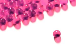 cápsulas de bola esférica rosa de plástico com foco seletivo isolado no fundo branco foto