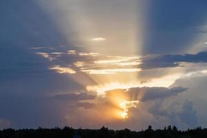 céu nublado do sol com raios de sol amarelos com horizonte foto