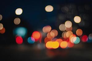 luzes de rua bokeh à noite, fundo desfocado de cores de tráfego da cidade foto