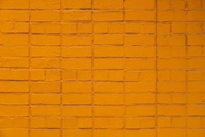 fundo plano e textura de parede de tijolos pintados de laranja fosco de quadro completo foto