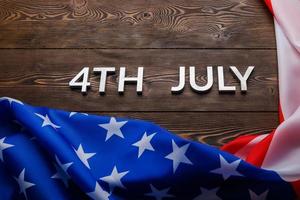 as palavras 4 de julho e bandeira dos eua amassada no fundo da superfície de madeira texturizada plana foto