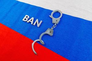 proibição de palavras colocada com letras prateadas e algemas sobre a bandeira da federação russa foto