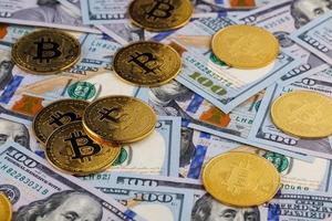 moedas de bitcoin amarelas espalhadas sobre notas de papel de dólar americano, closeup foto