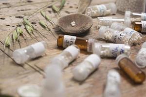garrafas com glóbulos de homeopatia e colher foto