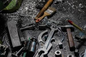 conjunto de ferramentas cobertas com aparas de metal de alumínio na mesa do trabalhador de máquinas foto