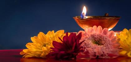 feliz Diwali. tradicional festival indiano de luz. queimando lâmpadas de óleo diya e flores sobre fundo vermelho. foto