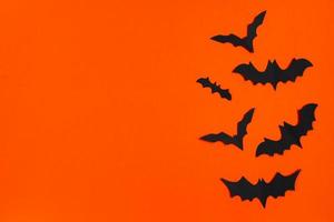 feliz Dia das Bruxas. morcegos de papel em fundo laranja. foto