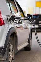 carro metálico cinza reabastecimento no posto de gasolina - closeup com foco seletivo foto