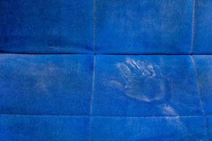 superfície do sofá azul empoeirado com palma imprime closeup com foco seletivo foto