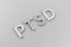 uma abreviatura ptsd - transtorno de estresse pós-traumático - colocado com letras de metal prateado na superfície plana cinza claro foto