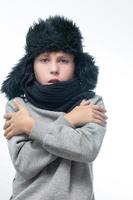 chapéu de inverno com protetores de ouvido e cachecol, retrato de um menino com roupas de inverno. foto