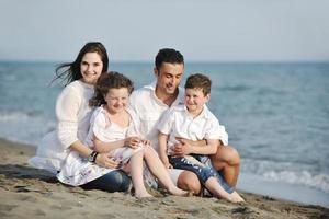 feliz jovem família se divertir na praia foto