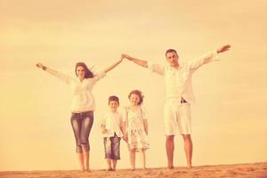 família na praia mostrando sinal de casa foto