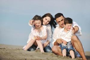 feliz jovem família se divertir na praia foto