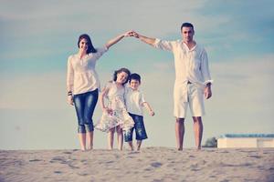 família na praia mostrando sinal de casa foto