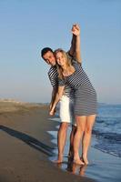 feliz casal jovem tem tempo romântico na praia foto