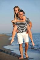 feliz casal jovem tem tempo romântico na praia foto