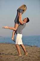 feliz casal jovem se divertir na praia foto