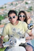 retrato de casal de amor jovem feliz na scooter aproveitando o horário de verão foto