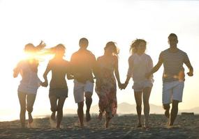 grupo de jovens felizes se divertem na praia foto