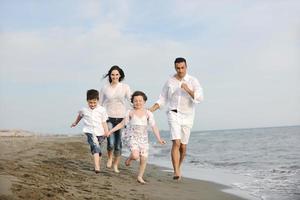 feliz jovem família se divertir na praia foto