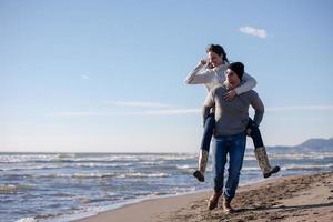 casal se divertindo na praia durante o outono foto