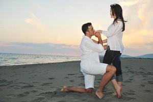 feliz casal jovem se divertir na praia foto