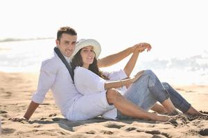 feliz casal jovem se diverte na bela praia foto