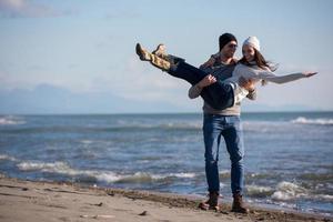 amando o jovem casal em uma praia em dia ensolarado de outono foto