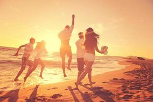 grupo de pessoas correndo na praia foto