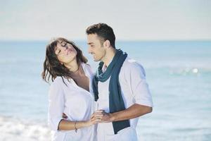 feliz casal jovem se diverte na bela praia foto