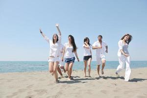 grupo de jovens felizes em se divertir na praia foto