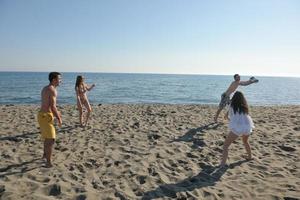 grupo de jovens se diverte e joga vôlei de praia foto