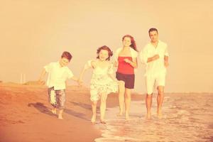 feliz jovem família se divertir na praia foto