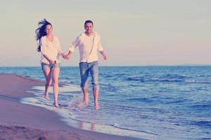 jovem casal na praia se divertir foto