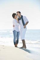 feliz casal jovem se diverte na bela praia foto