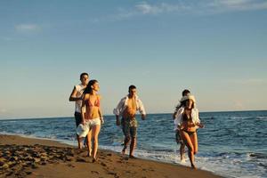 grupo de pessoas correndo na praia foto