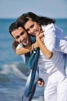 feliz casal jovem se diverte na bela praia foto