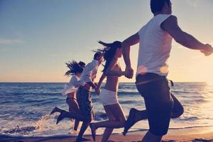 grupo de pessoas correndo na praia foto