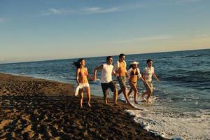 grupo de pessoas correndo na praia foto