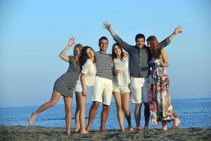 grupo de jovens felizes se divertem na praia foto